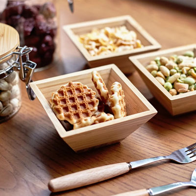Houten saladebak met natuurlijke vierkante bamboebakken en gedroogde fruitorganisator