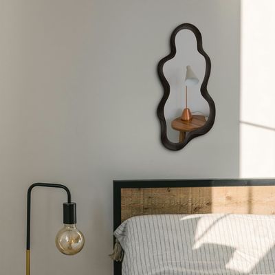 Prachtige woningversiering Onregelmatige wandspiegel met zwart houten frame en moderne badkamerversiering